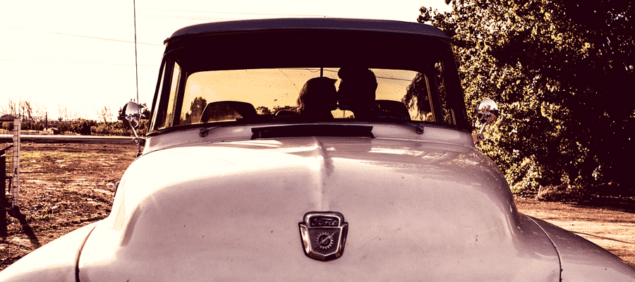 Couple kissing in an old car outside