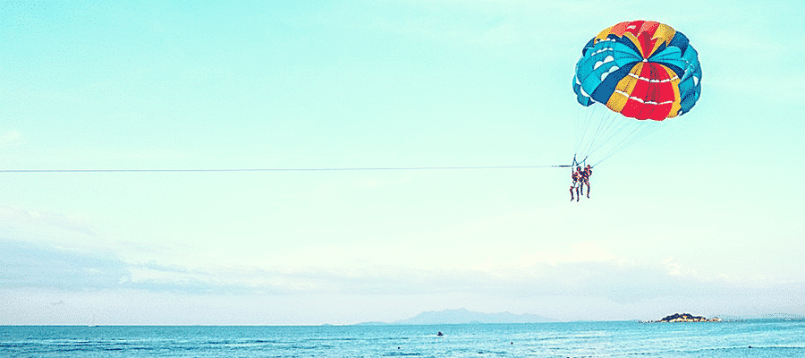 Couple para-sailing over ocean