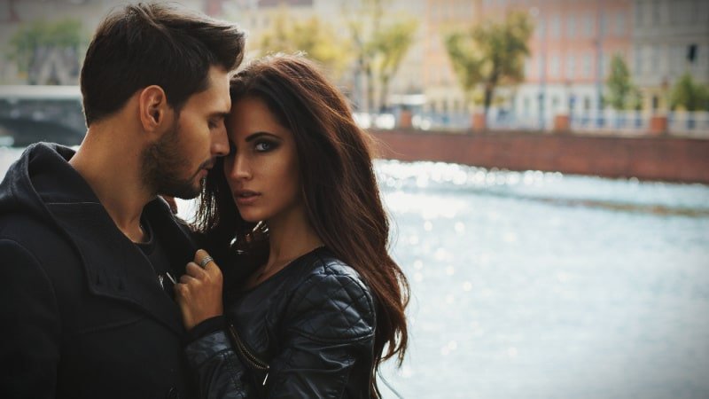 Attractive Couple Outside on River With Woman Looking at Camera