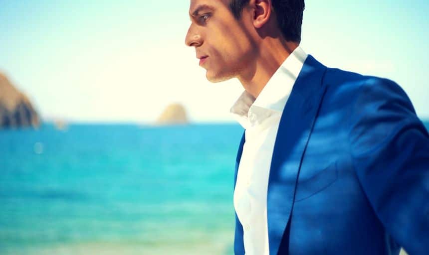 Attractive man in blue suit and white shirt at the beach