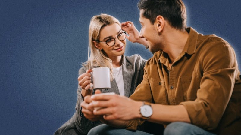 Attractive woman flirting with a guy on a couch with a coffee cup 3