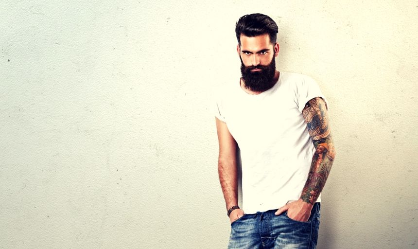 Bearded man with tattoos in white shirt and jeans