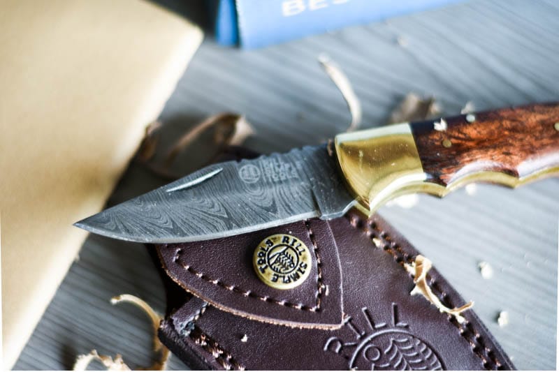 Bespoke Post Flip Knife On Top of Pouch With Wood Shavings