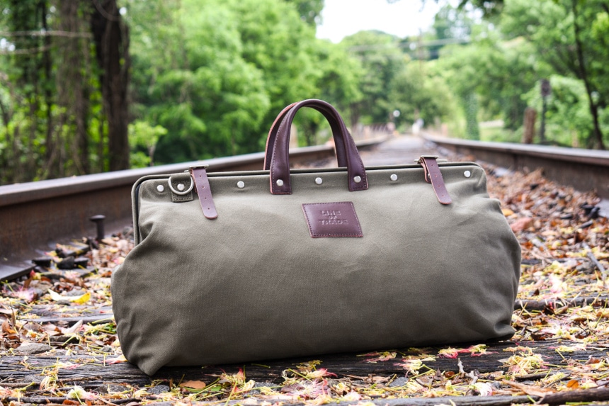 Bespoke Post Weekender Bag Outside on Railroad Sitting Up