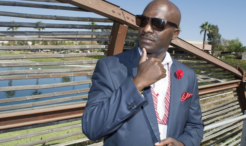 Black bald man in suit touching chin