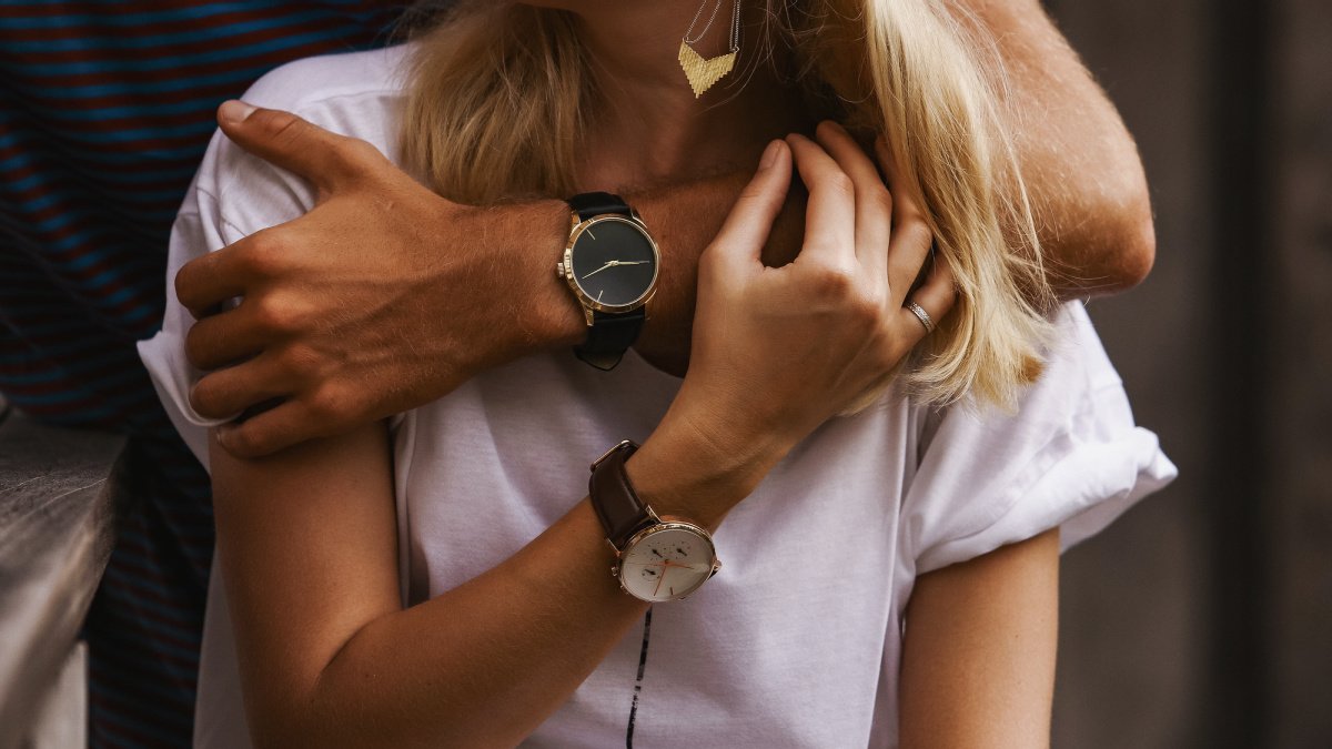 Couple Watches Man and Girlfriend Wearing His and Hers Watches and Hugging