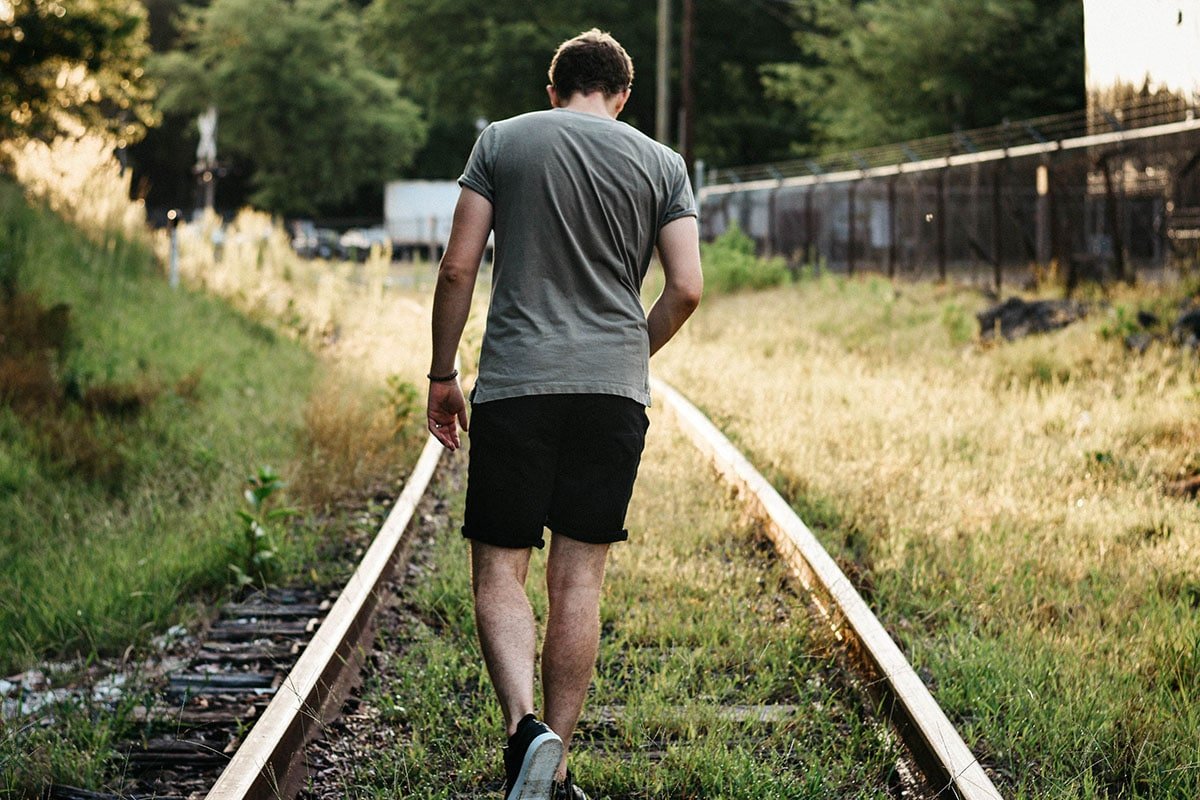DUER Review Model wearing Duer No Sweat Relaxed Fit Denim Shorts on Train Track