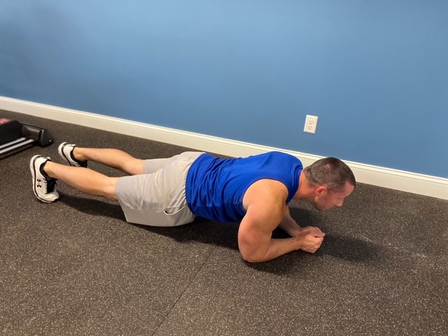 Fitness model performing plank exercise indoors