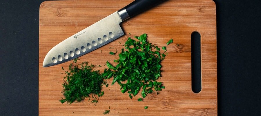 Knife with cutting board and herbs