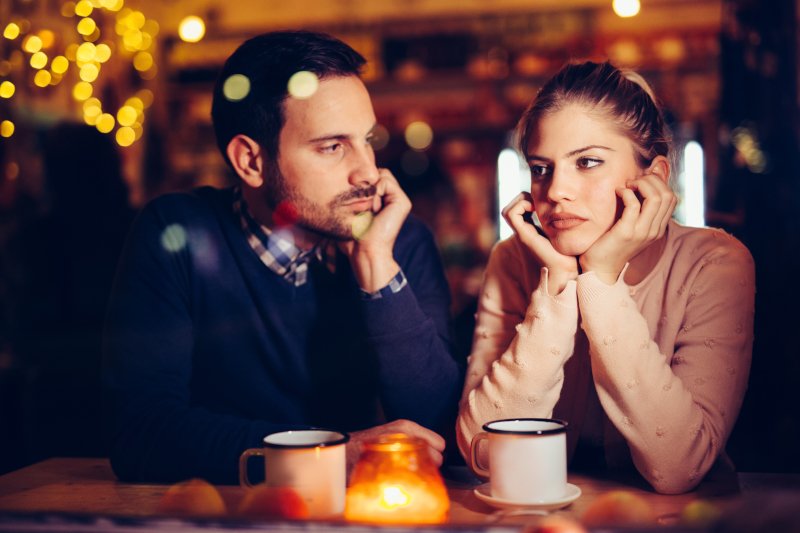 Guy and girl on a date while sad and disinterested