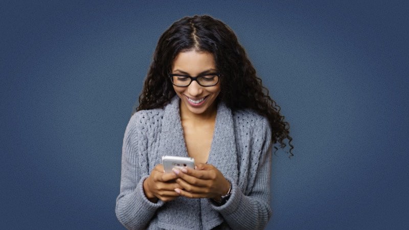 Happy black woman texting and smiling 1