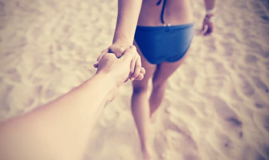 Holding hands with girl on the beach