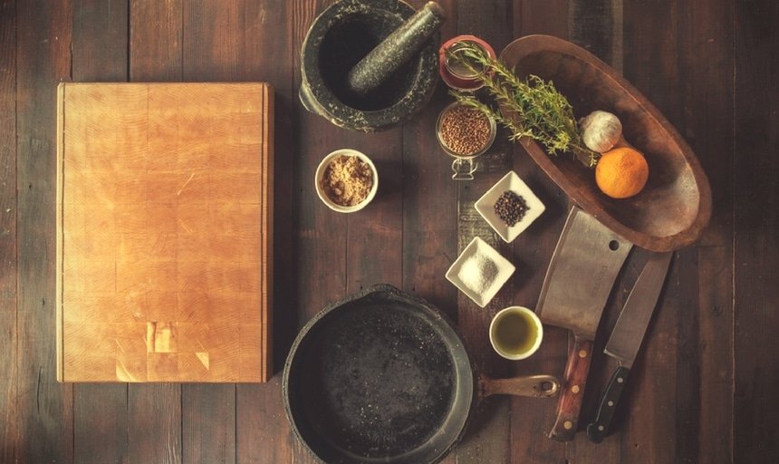 Ingredients and utensils and cookware on wooden bench