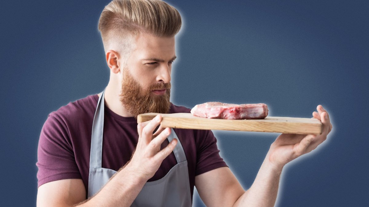 Keto for Men Man Focusing on Steak While Holding Chopping Board