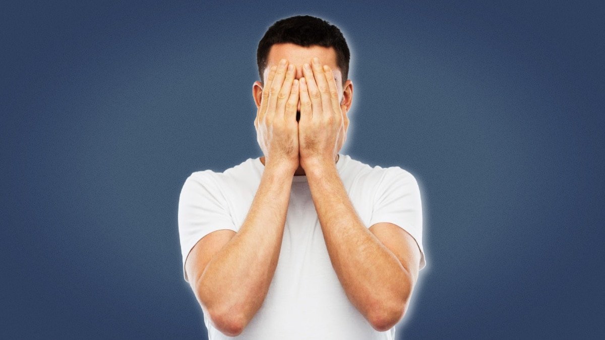 Life Sucks Man in White Shirt Holding Hands Over Face Blank Background