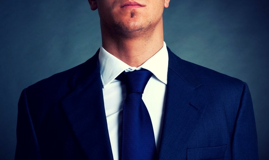 Man closeup with navy tie and navy suit with white shirt