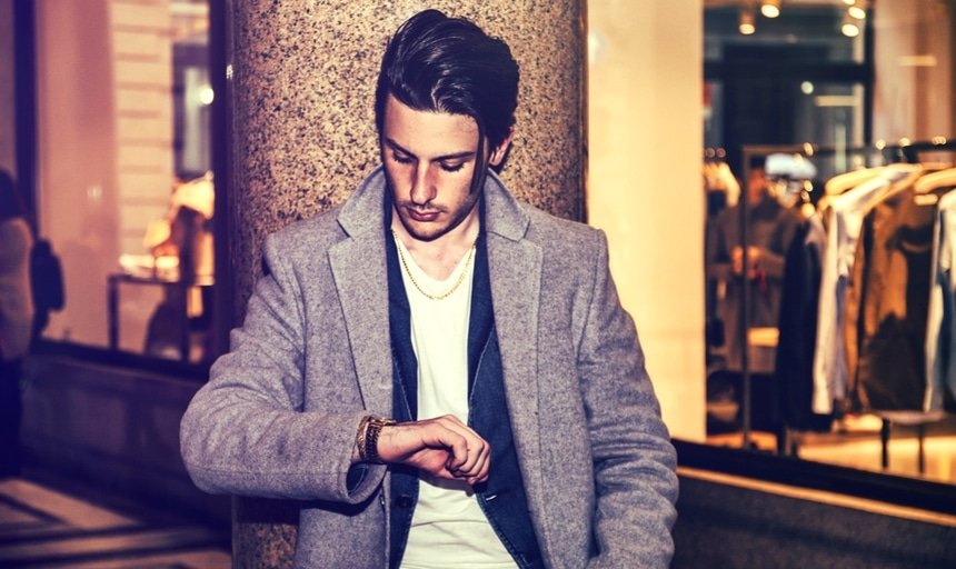 Man in camel coat elegant looking at watch