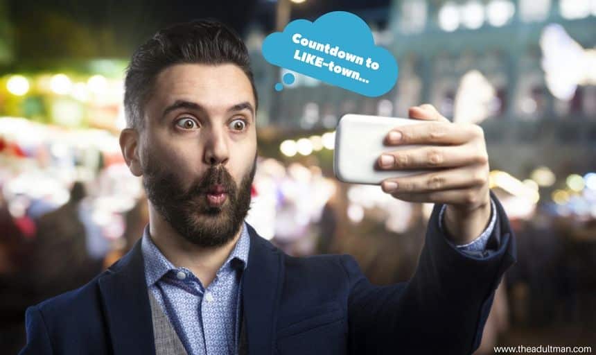 Man in suit with beard posing for selfie