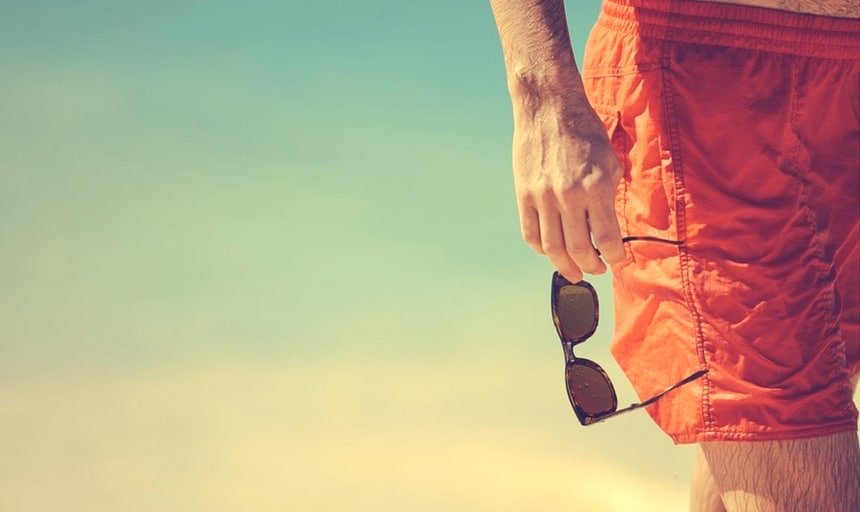 Man in swimming trunks with sunglasses