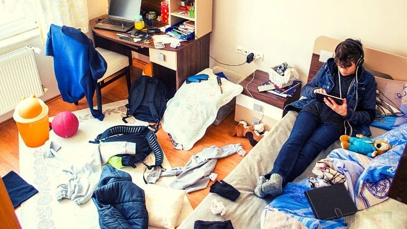 Man on Bed with Messy Bedroom
