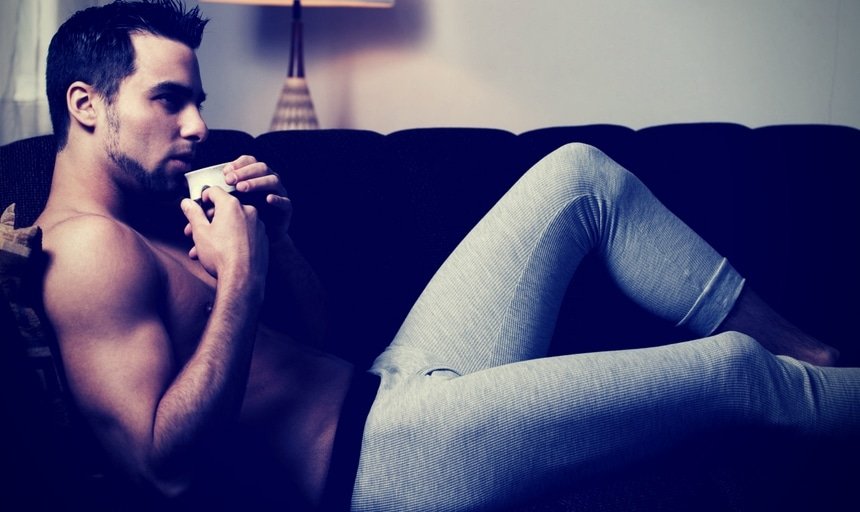 Man on couch in pajamas with coffee