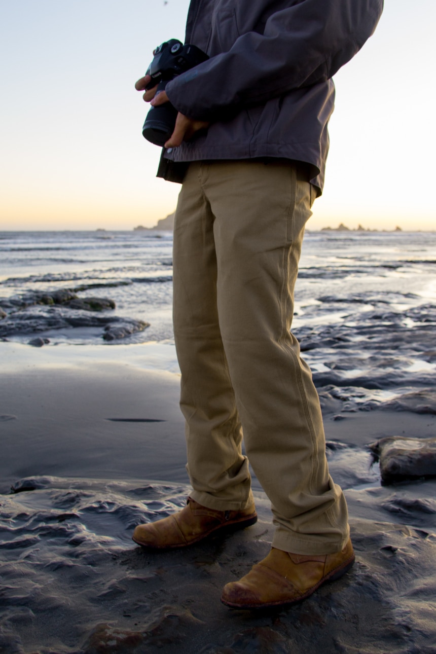 Man on seashore holding camera wearing Carhartt Shortline Jacket and Rugged Flex Rigby Dungaree