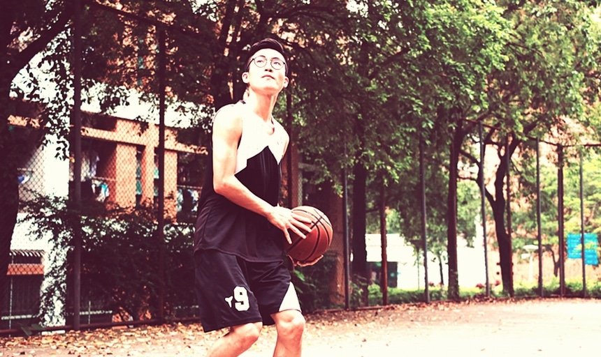 Man playing basketball with glasses in black and white uniform