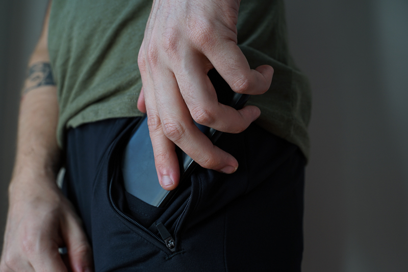 man putting cell phone into Barbell pants