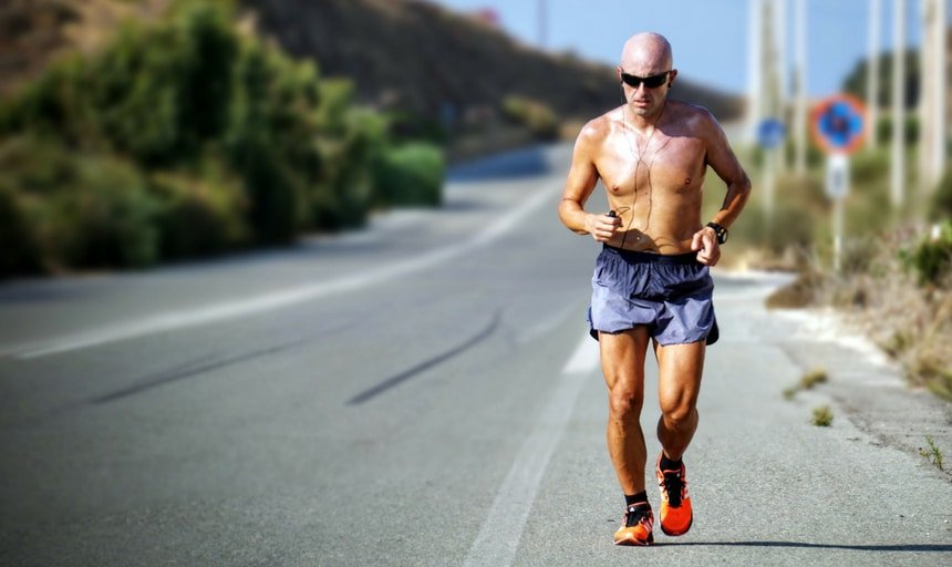 Man running shirtless on the side of the road