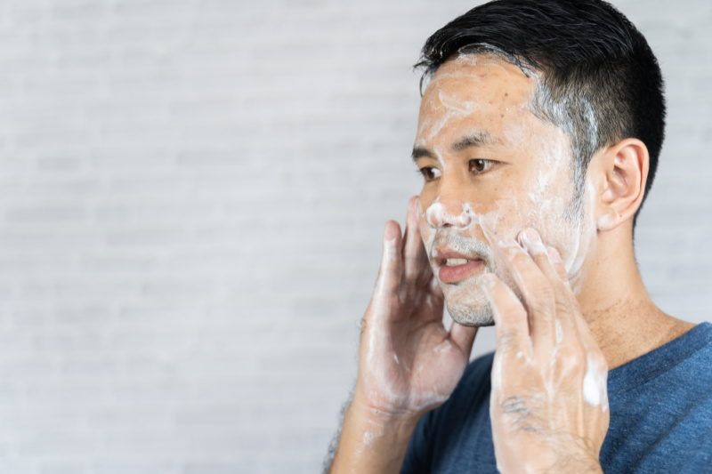 man using face wash on skin