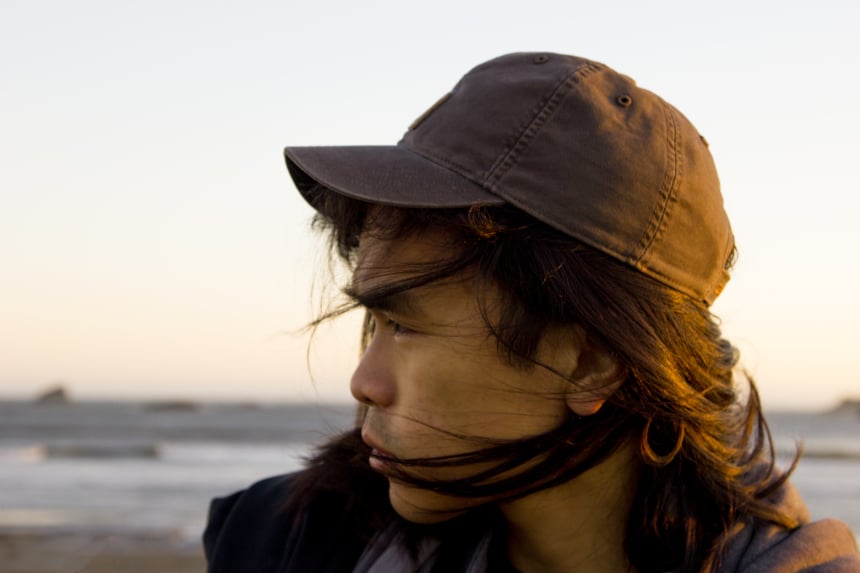 Man with long hair on beach wearing Carhartt Odessa Cap