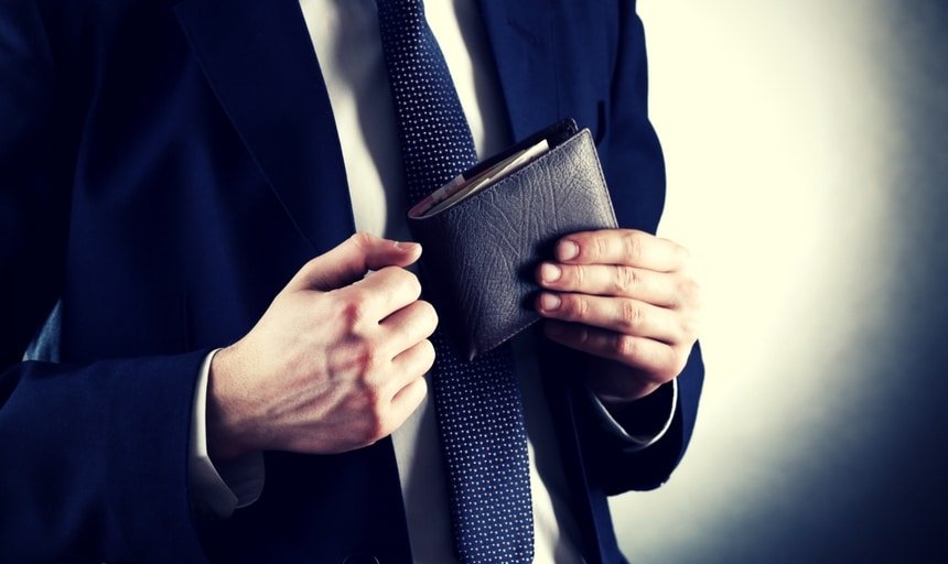Man with suit holding leather wallet