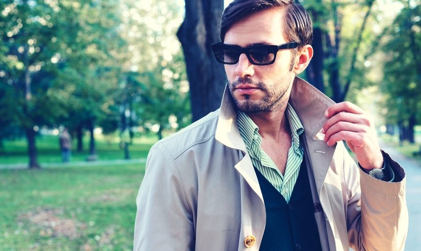 Man with trench coat and sunglasses in park
