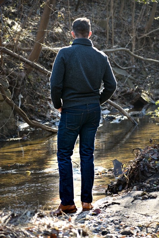 model at stream with shawl collar sweater and jeans
