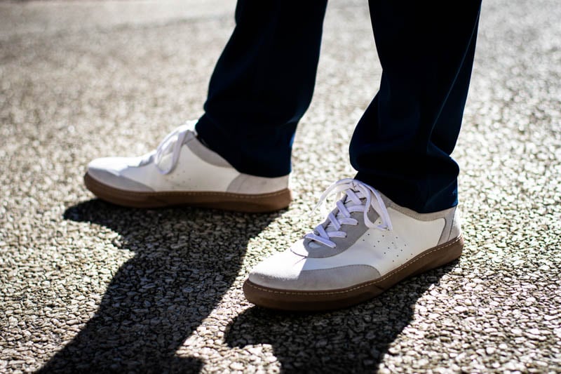 model backlit wearing white moral code brooks sneakers