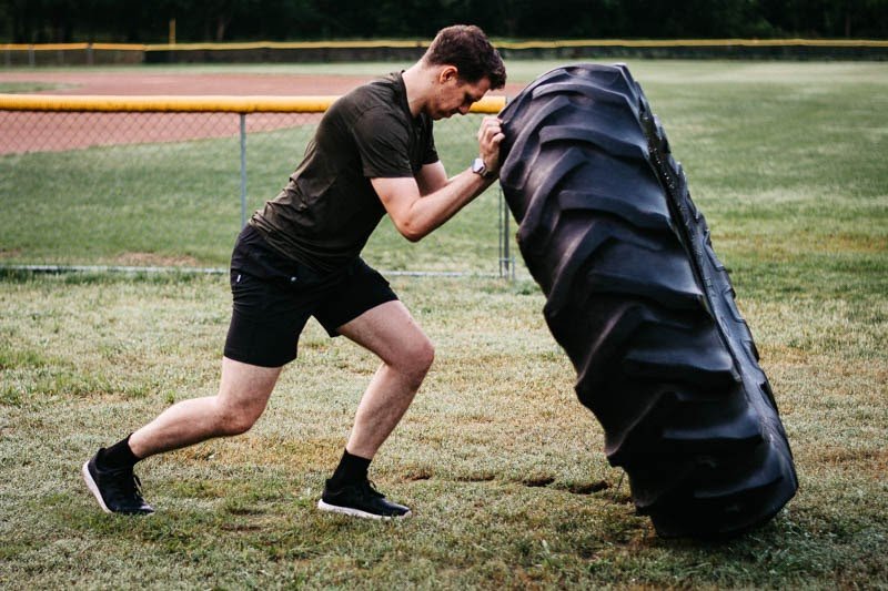 model flipping tire wearing kore workout shorts from vuori