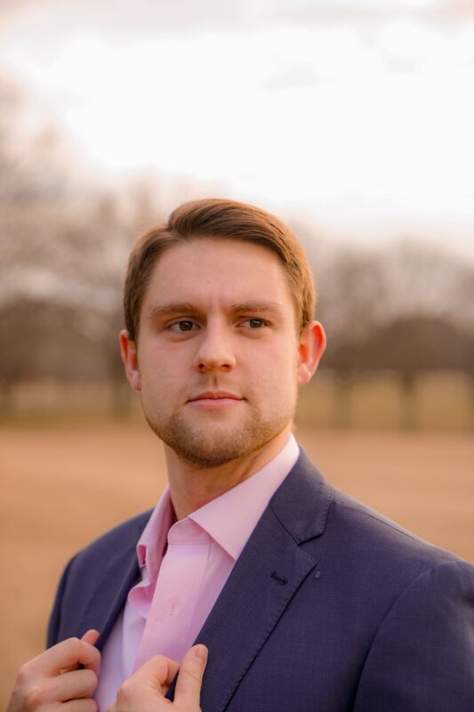 model in blue suit and pink shirt