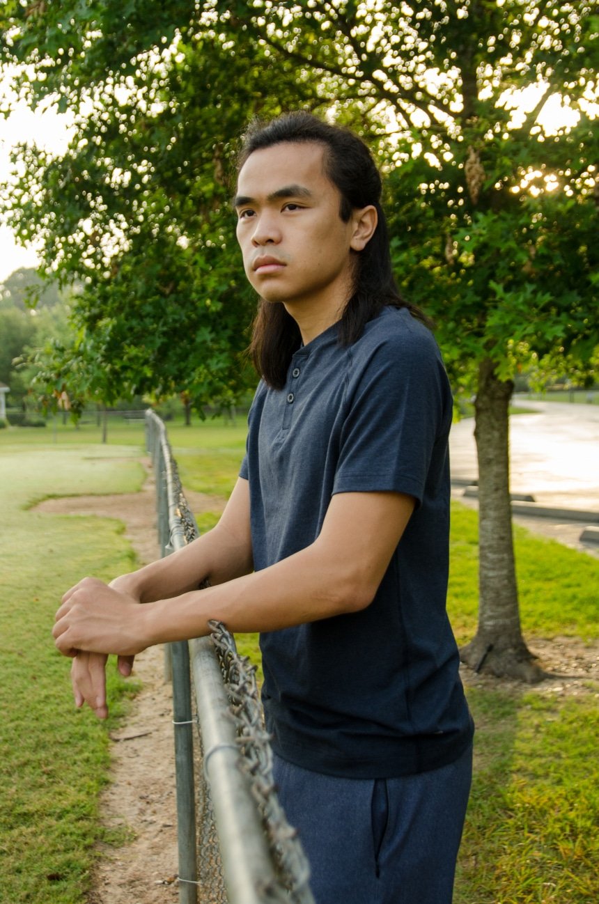 Model Leaning Against Fence Wearing Public Rec Go-To Henley