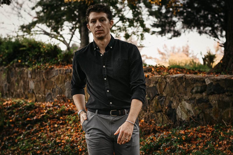 model looking at camera with black Frank and Oak oxford button down