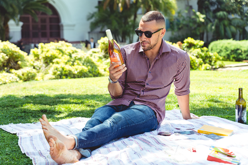 Model sits in park and reads wine label