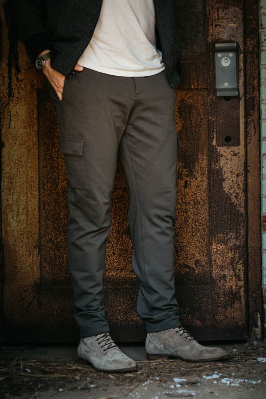 model standing against textured doorway wearing paige cruz cargo trousers and mgemi fuggire suede boots with everlane premium weight tshirt