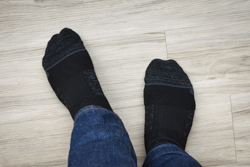 model standing with black crew strideline socks against wood background