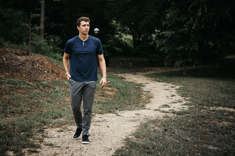 model walking along dirt path wearing rhone notch tee