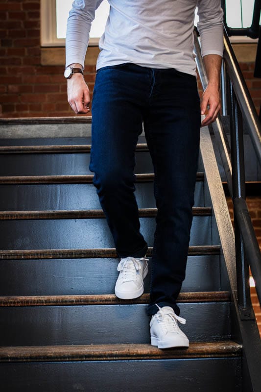model walking down stairs with jeans and rb1 low rag and bone white minimalist sneakers
