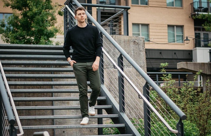 model walking down steel steps with olive asket chinos