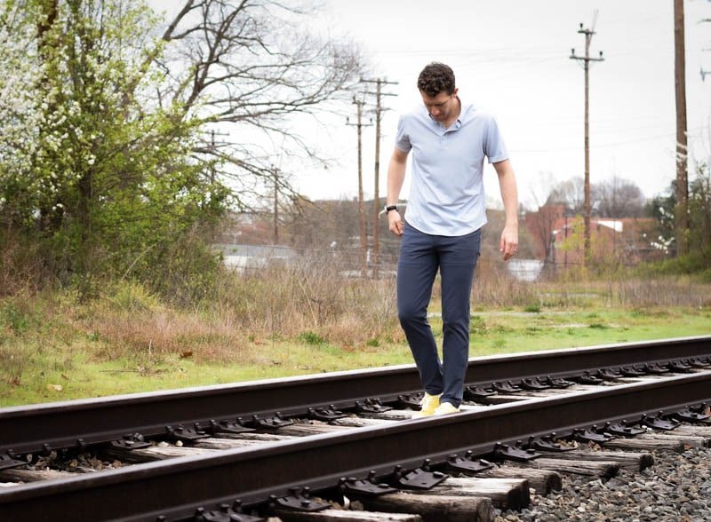 model walking down train tracks wearing western rise limitess shirt and diversion pants