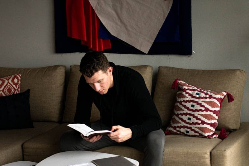 model wearing black hoodie reading book