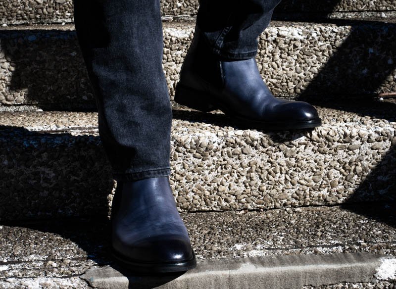 model wearing blue chelsea boots moral code on stair case