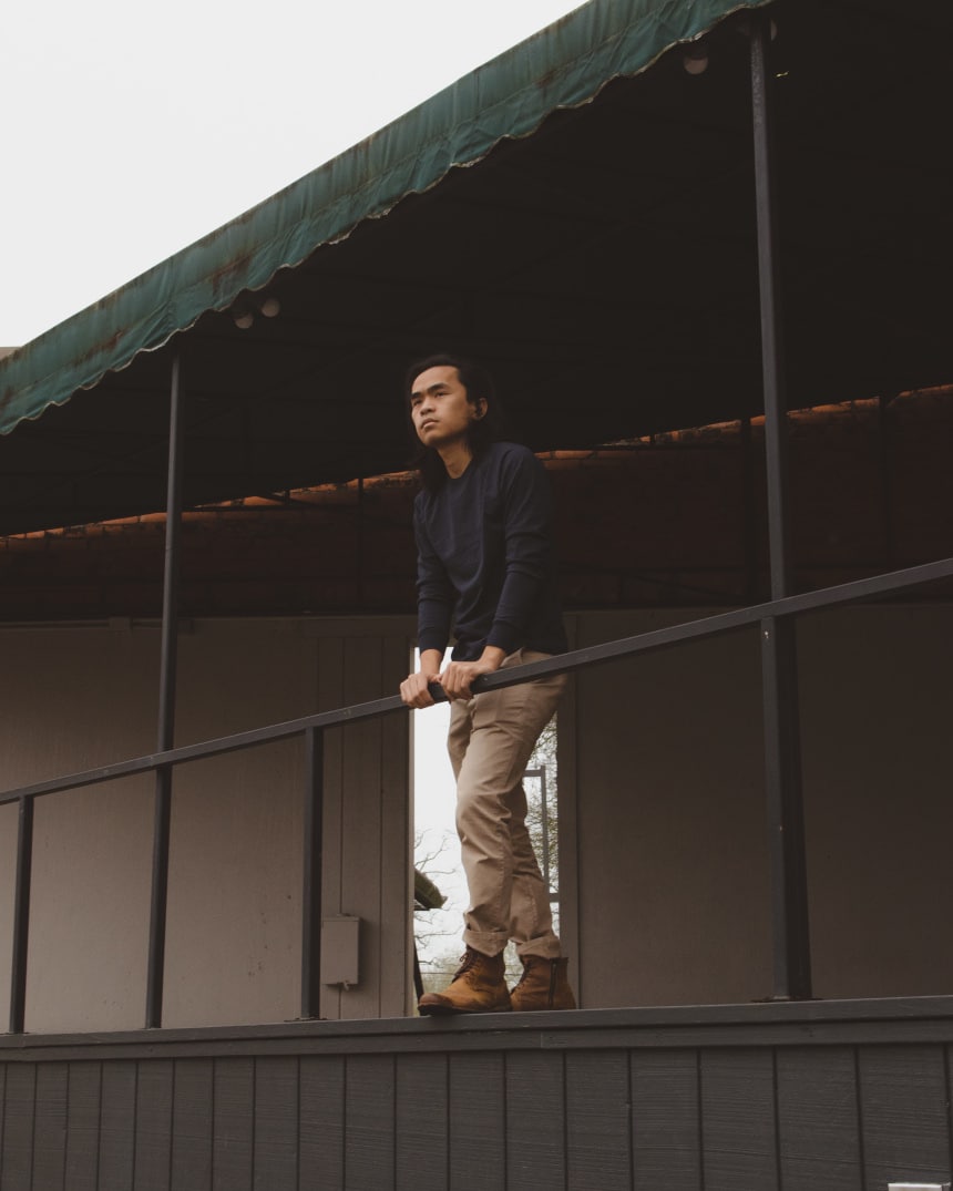 Model wearing Everlane heavyweight long sleeve tee and midweight slim chino and standing outside