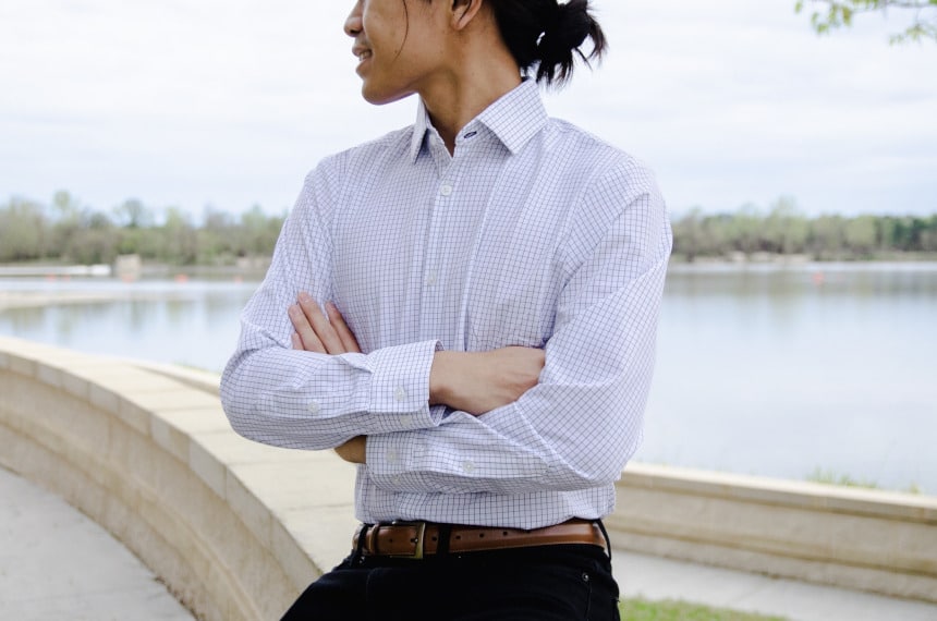 Model Wearing Mizzen+Main Kennedy Dress Shirt Sitting Down and Smiling While Crossing Hands